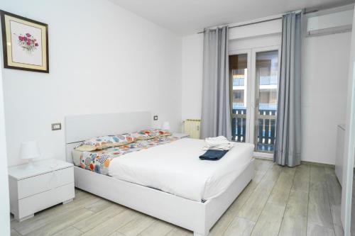 a white bedroom with a bed and a window at IL BACIO Guest House - Affitti Brevi Italia in Perugia
