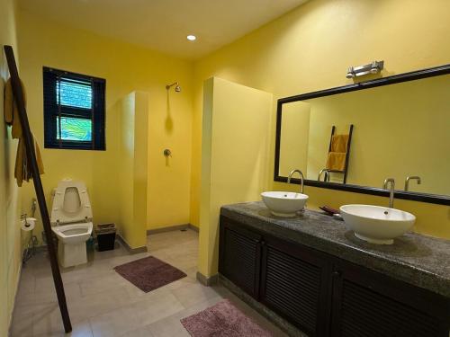een badkamer met twee wastafels en een spiegel en een toilet bij Luxury Pool Villa - Sawan - 4 Bedroom in Hua Hin