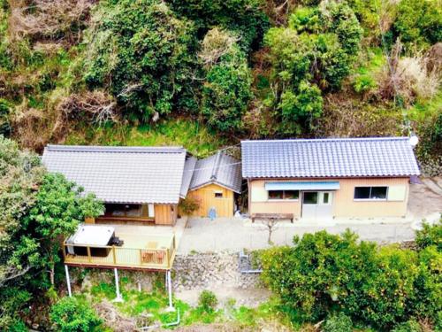 Una vista aérea de dos casas con árboles. en ハイランドビュー, 