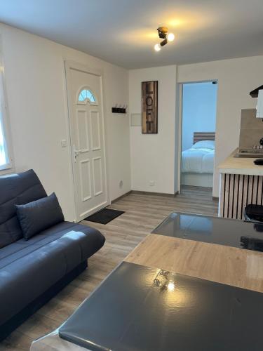 un soggiorno con un divano e un tavolo di Appartement indépendant a Caussols