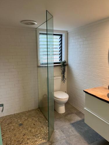 a bathroom with a toilet and a window at Stokes Bay Surf Shack in Stokes Bay