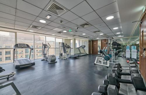 a gym with treadmills and elliptical machines at Grand Stay Holiday Homes Rental 2 in Dubai