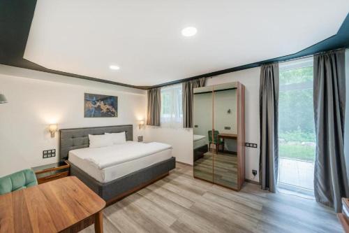 ein Schlafzimmer mit einem Bett, einem Tisch und einem Spiegel in der Unterkunft SMARTHOTEL Aalen in Aalen