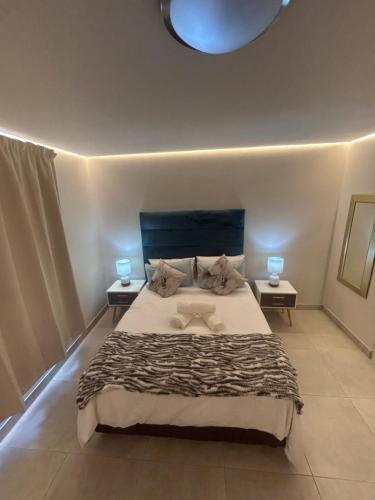 a bedroom with a large bed with two tables at Immaculate,Alttrative &Modern 1 Noload shedding in Cape Town