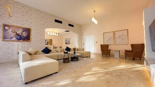 Luxurious Al Danah 5BR Family Friendly Getaway في أبوظبي: غرفة معيشة مع أريكة وكراسي