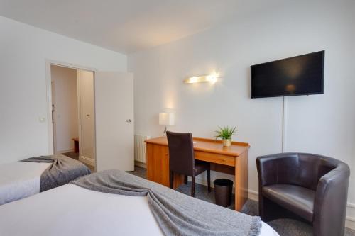 a hotel room with a desk and a computer at Brit Hotel le Cygne in Saint-Hilaire-du-Harcouët