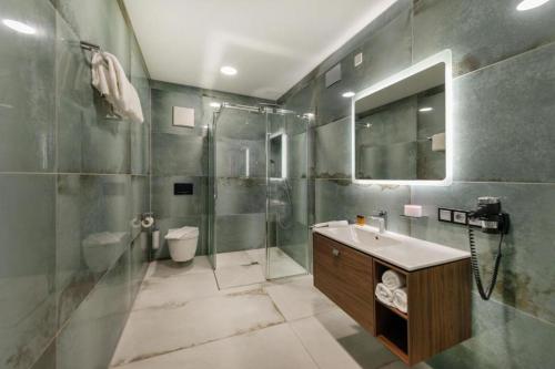 ein Badezimmer mit Dusche, Waschbecken und Toilette in der Unterkunft SMARTHOTEL Aalen in Aalen