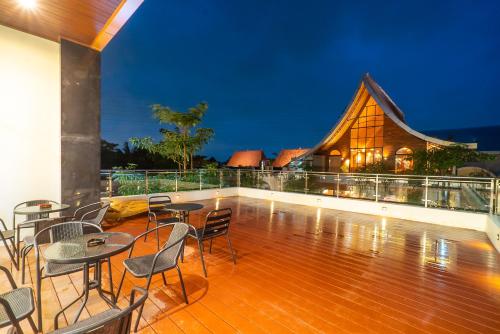 a balcony with tables and chairs and a building at Gomini Stay in Cebongan