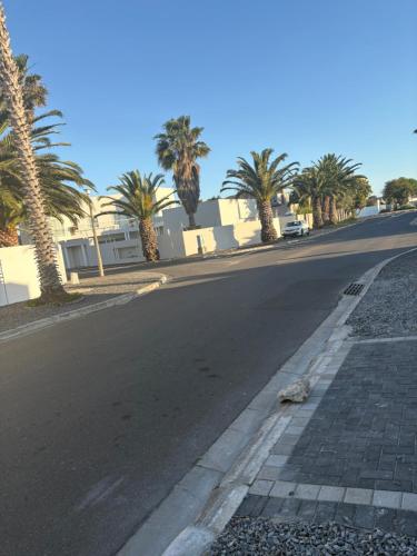 an empty street with palm trees on the side of the road at Immaculate,Alttrative &Modern 1 Noload shedding in Cape Town