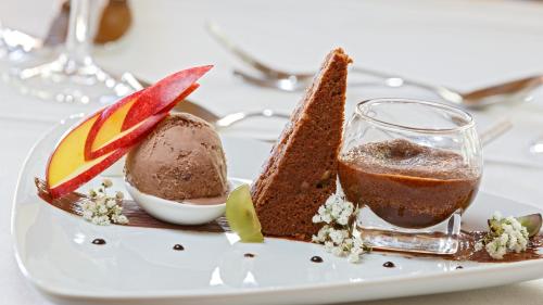 a white plate with a piece of cake and ice cream at Griesalp Hotels in Kiental