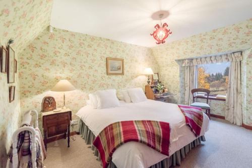 a bedroom with a large bed with floral wallpaper at Glenogle Highland Estate Home in Lochearnhead