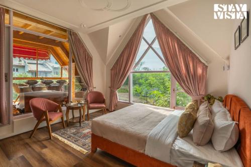 a bedroom with a bed and a large window at StayVista at Emaarat Chalet with BBQ & Bonfire in Srinagar