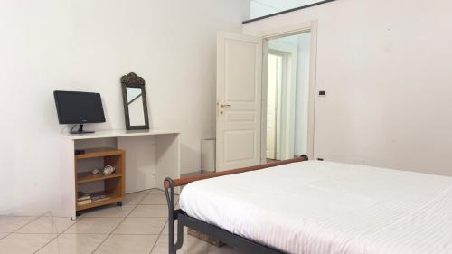 a bedroom with a bed and a tv on a shelf at GAUDIO APPARTAMENTs A DUE PASSI DAL TEATRO ARISTON NEL CENTRO DI SANREMO in Sanremo