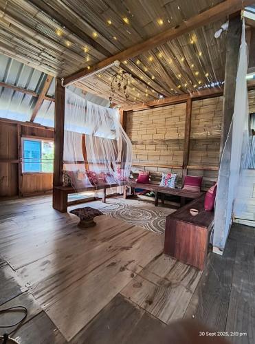 a large room with benches in a wooden building at Stargaze Backpackers Ziro in Ziro