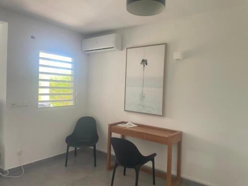 a room with two chairs and a table and a picture at Friar's beach - Luxurious unit by the beach in Friar's Bay