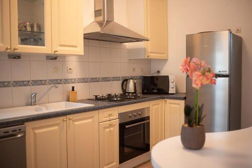 a kitchen with white cabinets and a stainless steel refrigerator at Charming room apartment in Dunkerque