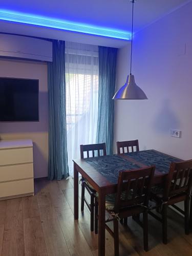 a dining room with a table and chairs and a tv at Tp Apartman in Tapolca