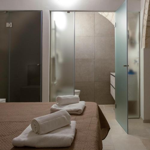 a bathroom with two towels sitting on a bed at Lanucara 5 in Martina Franca