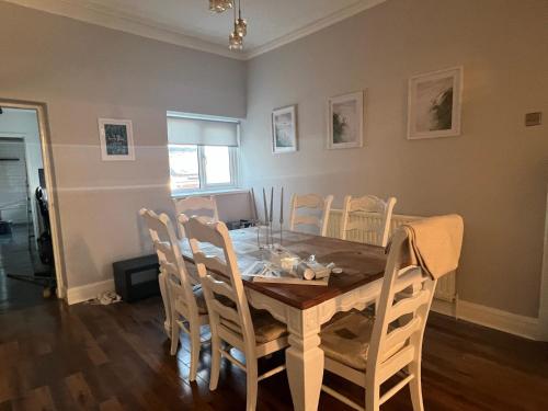 a dining room with a wooden table and chairs at AA Exec Apartments in South Shields