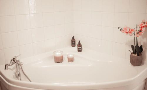 a white bathroom sink with candles and flowers on it at Charming room apartment in Dunkerque