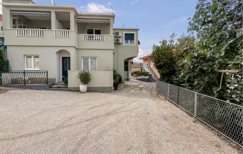 a large white house with a fence in front of it at Beautiful Apartment In Duce With House Sea View in Duće