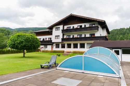 a building with a blue cover and a bench at Pension Tilly in Niederöblarn