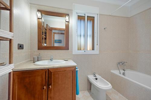 ein Badezimmer mit Waschbecken, Badewanne und Toilette in der Unterkunft Chalet con Piscina Privada in Poblado de Sancti Petri