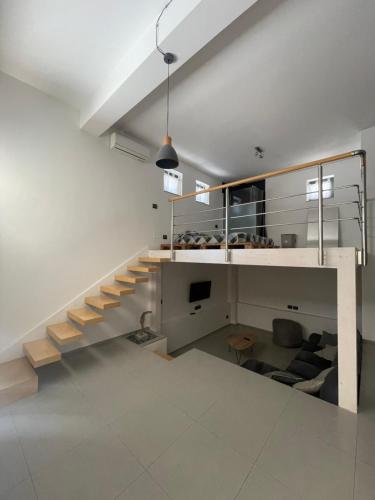 a living room with stairs and a couch and a tv at Casa Terranova in Pozzallo