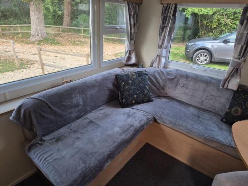 a couch in a living room with a window at 3 bedroom caravan 14 kingsgate in Shanklin