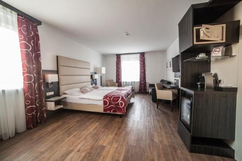 a hotel room with a bed and a desk at Hotel Stadt Cuxhaven in Cuxhaven