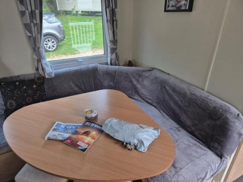 a round table with a magazine and a book at 3 bedroom caravan 14 kingsgate in Shanklin