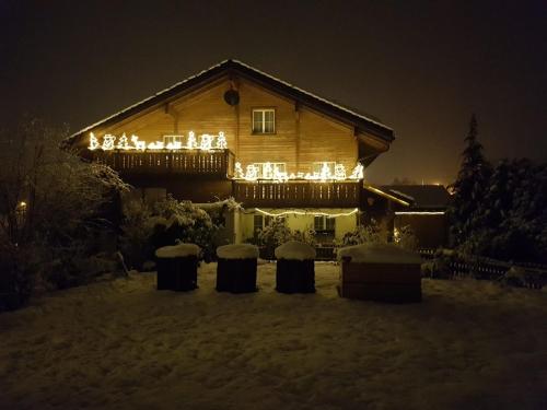 a house with a deck with lights on it at Ferienwohnung Bergzyt oder das Bed and Breakfast - Älplersuite mit eigenem Bad und Terrasse in Linthal