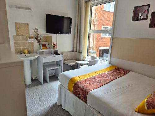 a hotel room with a bed and a sink at Glendor Hotel in Blackpool