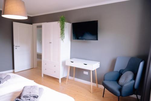 a bedroom with a bed and a blue chair and a desk at Ferienhaus Glücksgriff Pottenstein in Pottenstein