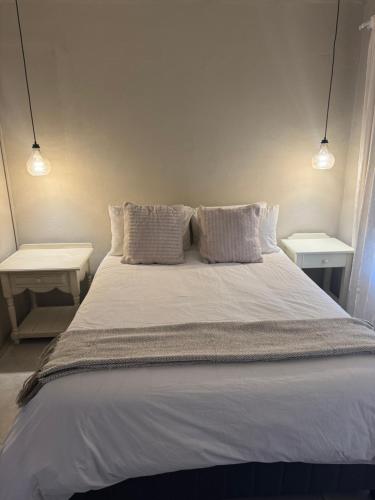 a large white bed with two nightstands and two lamps at The Pecan Cottage in Somerset East
