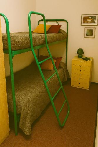 a bunk bed with a green ladder in a room at Artesina in Sella della Turra