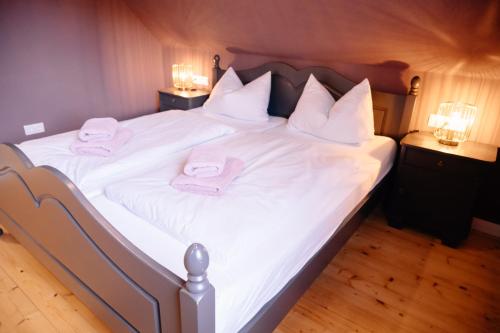 a large bed with white sheets and towels on it at Ferienhaus Glücksgriff Pottenstein in Pottenstein