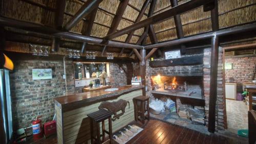 a bar with a fireplace in a brick room at Harmony Luxury Tents & Safari in Addo