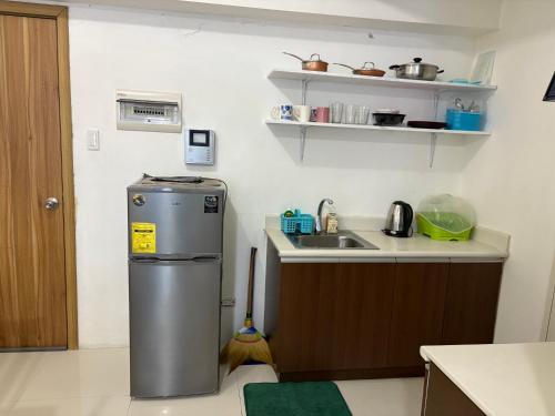 a small kitchen with a sink and a refrigerator at Urban haven Family&Barkada room in Manila