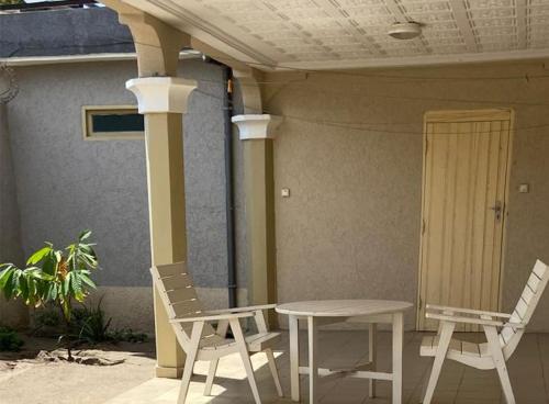two chairs and a table in front of a house at Hébergement Lomé Awatamé réservation 24 Heures avant 