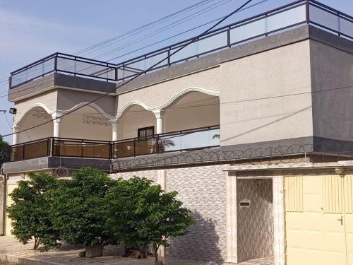 a building with a balcony and a garage at Hébergement Lomé Awatamé réservation 24 Heures avant 