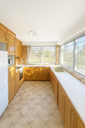 a large kitchen with wooden cabinets and white appliances at Mulberry House by the Sea Νέα Μάκρη in Nea Makri