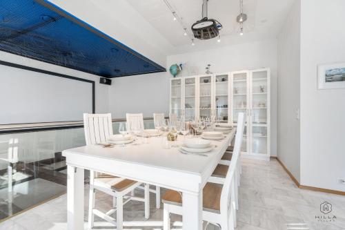 Un comedor blanco con una mesa y sillas blancas. en Kataja Hideaway Residence by Hilla Villas, en Rovaniemi