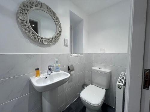 Un baño con inodoro, lavabo y espejo. en Inn Keepers Cottage, en Ulverston