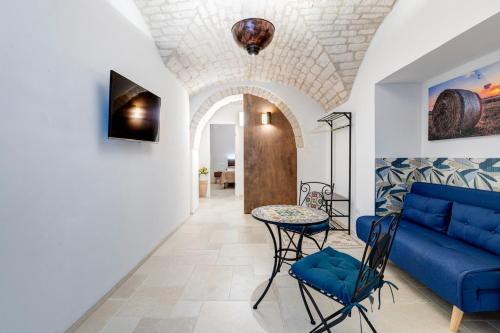 een woonkamer met een blauwe bank en een tafel bij Lanucara 6 in Martina Franca