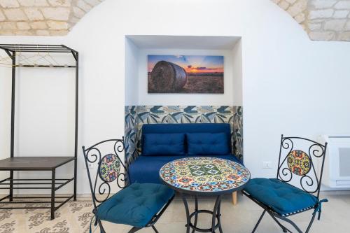 een kamer met een blauwe bank en een tafel en stoelen bij Lanucara 6 in Martina Franca