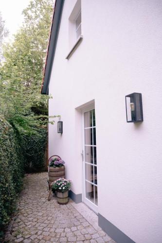 a white house with a door and a chair at Ferienhaus Glücksgriff Pottenstein in Pottenstein