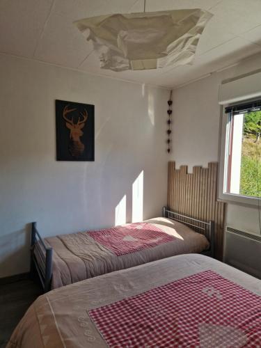 a bedroom with two beds and a ceiling at La Bresse OURSON in La Bresse