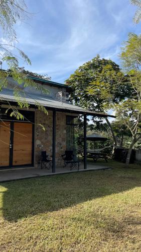 a stone house with a garage and a patio at Cabaña en cafetales de Huatusco 