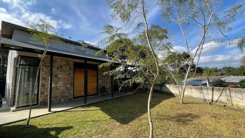 a stone house with a tree in front of it at Cabaña en cafetales de Huatusco 